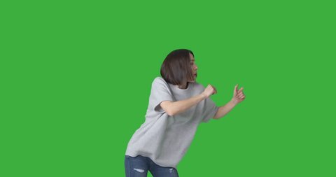 Ecstatic woman dancing over green background