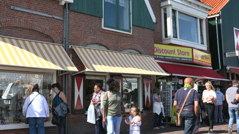 Volendam, Netherlands -August 18, 2018: Tourists walking near typical small Dutch houses with beautiful facades in Volendam. 4K