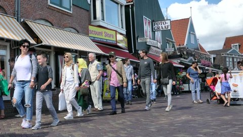 Volendam, Netherlands -August 18, 2018: Tourists walking near typical small Dutch houses with beautiful facades in Volendam. 4K