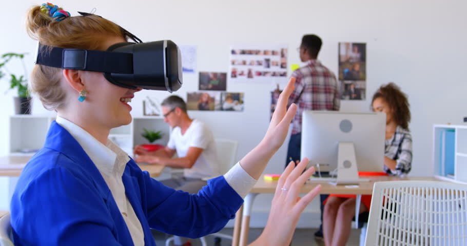 Side view of pretty Caucasian businesswoman using virtual reality headset in modern office. Diverse coworkers working in the background | Shutterstock HD Video #1026263618