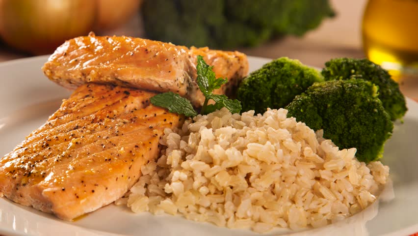 Slide shot Grilled salmon, rice and vegetables with smoke.