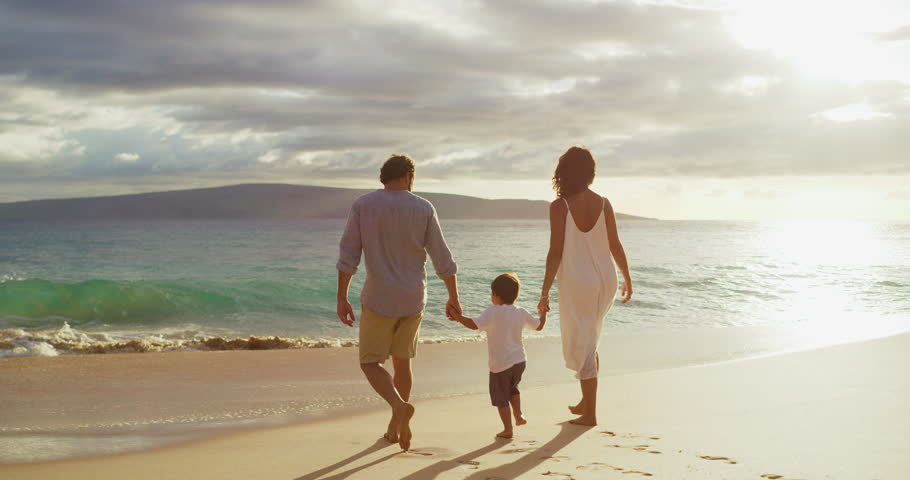 Happy mom and dad with small toddler son walking on the beach at sunset, island family vacation Royalty-Free Stock Footage #1026285398