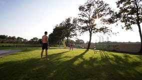 Man and women in swimwear playing frisbee on villa lawn as sunsets - Powered by Shutterstock - Get 15% off with code: PIKWIZARD15