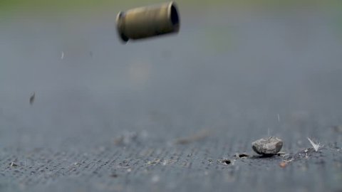macro shoot of impact  bullet shell falling in slow motion on the ground
