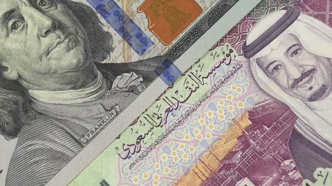 Saudi Arabia riyal against US dollar bill rotating. Saudi Arabia and USA trade, economy. 4K stock video footage