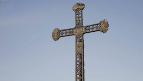 Metal cross with inscription INRI. Christian catholic symbol of faith. Bright blue sky in background, day shot