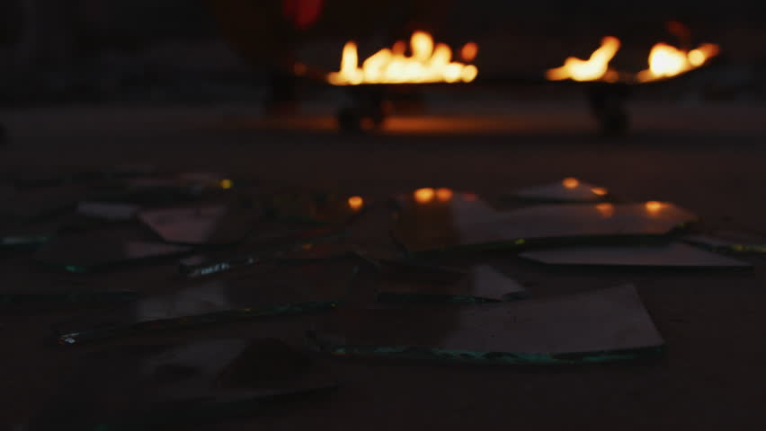 Man standing next to broken glass and a flaming skateboard. | Shutterstock HD Video #1026293468