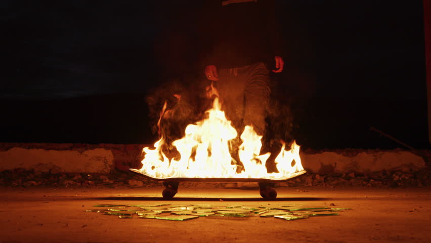 One person trying to break a flaming skateboard. | Shutterstock HD Video #1026293474