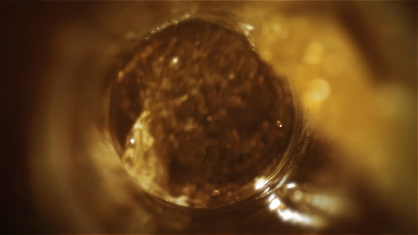 Beer is pouring from the top into the glass forming waves.Microbrewery Close-up. Slow-motion Cold Light Craft Beer in a glass. | Shutterstock HD Video #1026295214