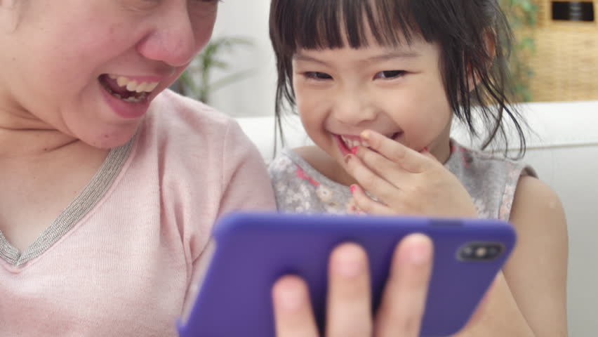 Happy asian family mother and daughter watching on phone and expand with smile face.  Royalty-Free Stock Footage #1026302267