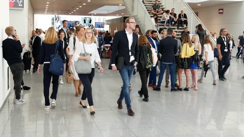 Duesseldorf, Germany - February 1, 2019 - Young business people at digital marketing exhibition and trade show in Duesseldorf walking and talking during lunch break.