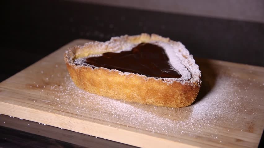 Cutting slice of heart shaped cheesecake close up shoot