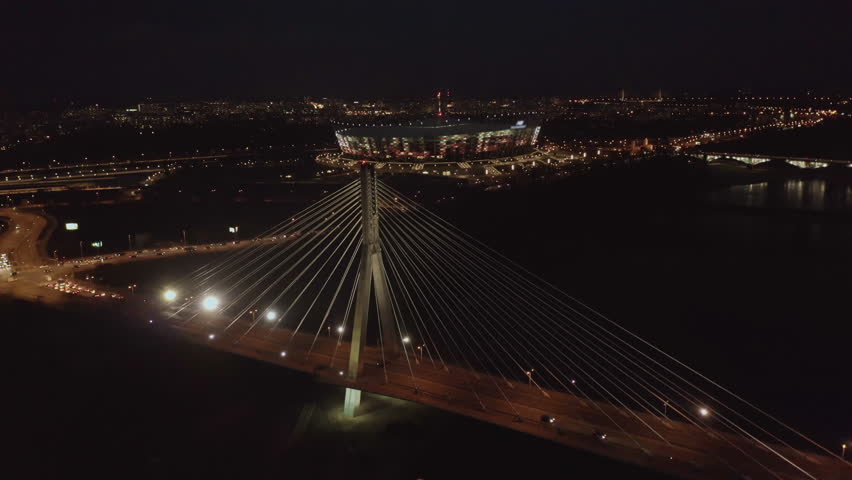 4K. Aerial pan of downtown Warsaw skyscrapers and bridge dark winter night light.