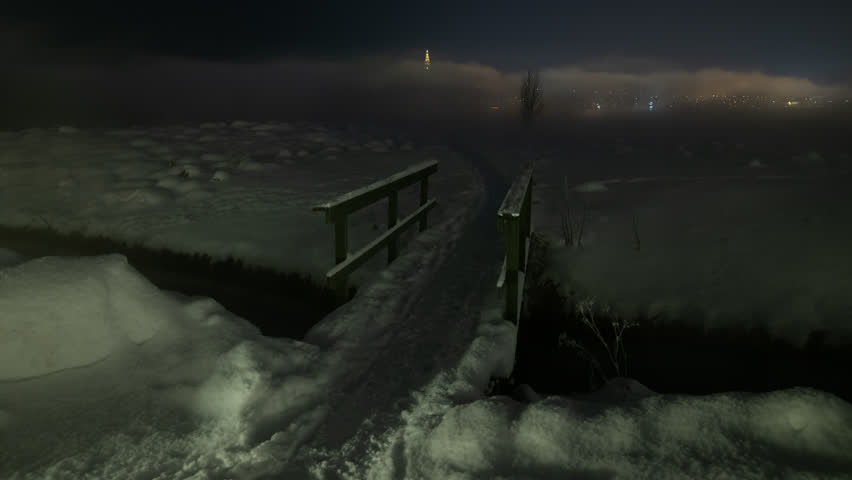 Snow covered walkway disappearing into thick fog Reykjavik Iceland winter night time lapse