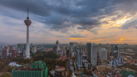 KUALA LUMPUR, MALAYSIA - JANUARY 2016 : Time lapse sunset in the city overlooking the national landmark, the Kuala Lumpur Tower with dancing clouds and rays. Zoom out motion timelapse