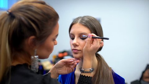 fashion show, visagist working, making professional make up, backstage. beautiful face of female girl model. Make up artist applying stylish makeup to young woman, visage for beauty contest 4 K