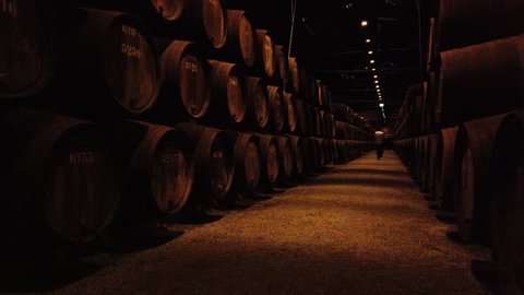 PORTO, PORTUGAL - CIRCA MARCH 2019: Port wine cellar, wooden barrels. Tawny port wine is aged in wooden barrels, stored in a cave before being bottled.