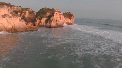 Cinematic Algarve Aerial. Alvor, Praia Tres Irmaos Beach, Portugal 4K. Calming Waves Splash On Cliff Rocks.