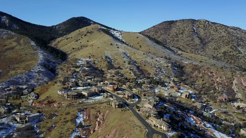 AERIAL: still shot looking at a few houses deep in the mountainous terrain within the Rocky Mountains in Colorado.