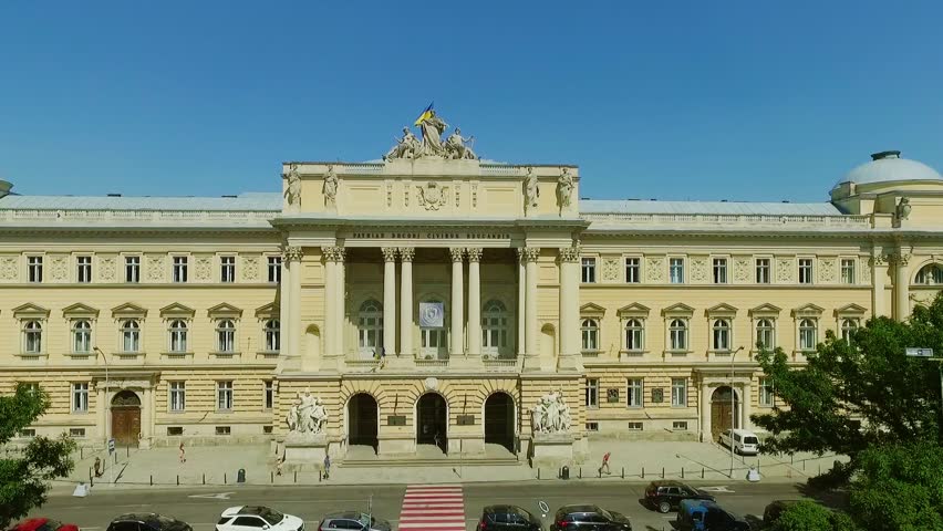 Drone flight footage of luxurious monumental exterior of the university building and cityscape with high tower on the distance. Old city, historical heritage, cityscape