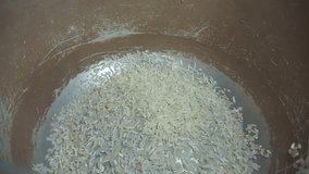 Footage of pouring rice into rice cooker pot