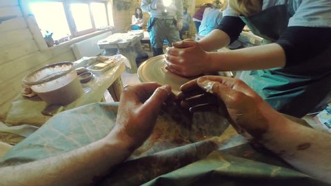 Lviv \ Ukraine - July 7 2017:Close up of hands working clay on potter's wheel in sunny studio artisan master handmade creativity sculpt handcraft art circle craft pottery workshop bowl brown ceramic