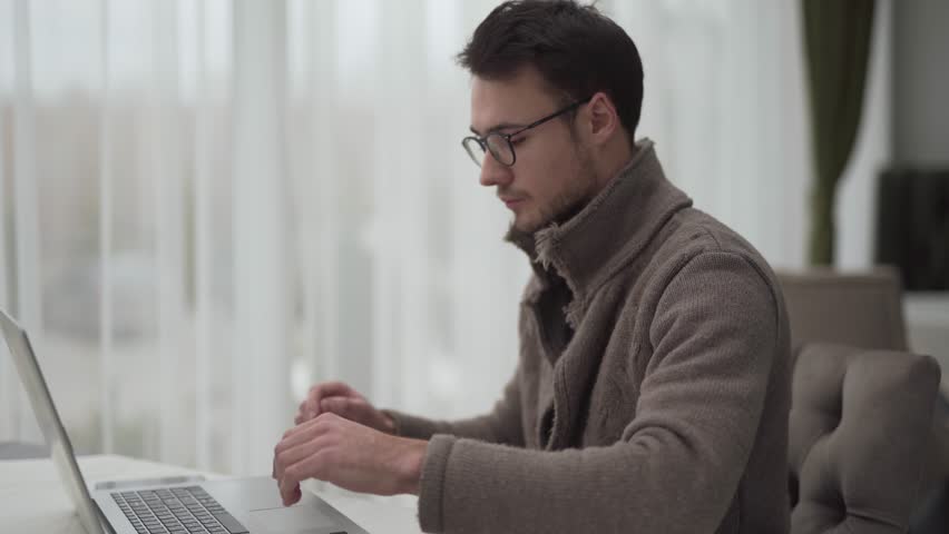 A close-up video with light blurred background is.A man works on his laptop on important project. He types, fills in tables with information and creates diagrams in the restaurant during lunch hour. | Shutterstock HD Video #1026394154