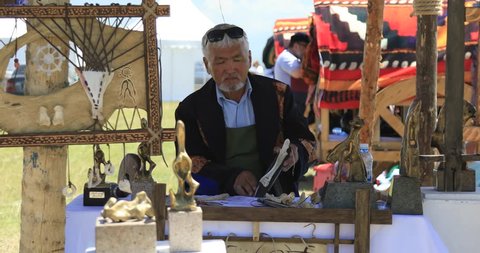 ALMATY - KAZAKHSTAN, JUNE: Artisan creating vintage folk musical instruments during the Great Steppe the world of nomadsthe festival. 