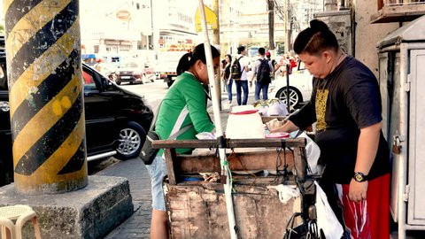 METRO MANILA, PHILIPPINES - CIRCA MARCH 2018: Vendors sell local delicates on a busy street circa March 2018 in Metro Manila, Philippines.
