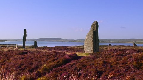 Pan across the ancient standing stones of the Ring of Brodgar Neolithic henge and stone circle, Mainland, Orkney, Scotland