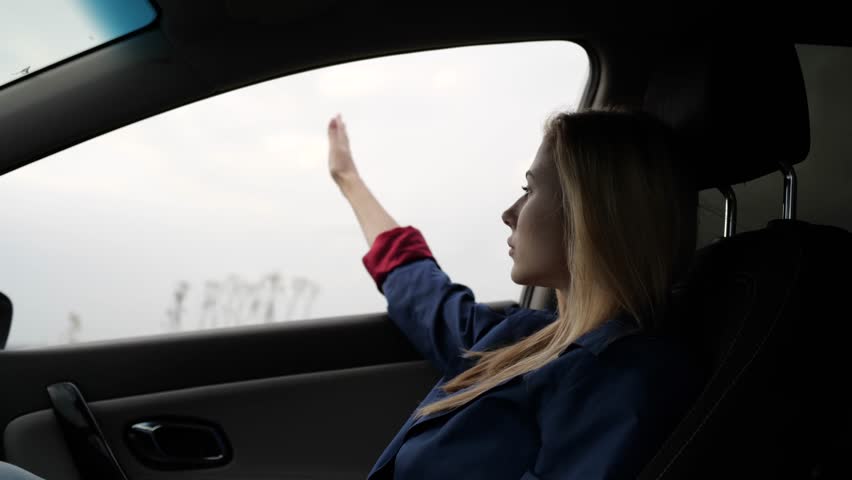 girl sitting in the car on the background of the field