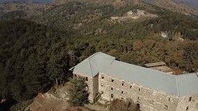 Video from the air. Video camera flies over an abandoned hotel in the mountains of Berengaria Troodos in Cyprus. Stone walls and Windows without glass, a collapsed wall. Sunny morning.