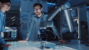 Diverse Team of Engineers with Laptop and a Tablet Analyse and Discuss How a Futuristic Robotic Arm Works and Moves a Metal Object. They are in a High Tech Research Laboratory with Modern Equipment. - Powered by Shutterstock - Get 15% off with code: PIKWIZARD15