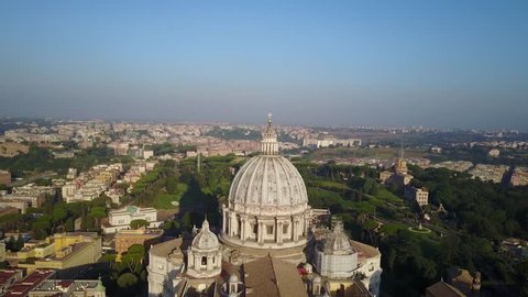 Aerial overlook of the cross on top of the dome of St. Peter's Basilica, and the obelisk at the center of Piazza San Pietro (St. Peter's Square). Vatican City. Roma.