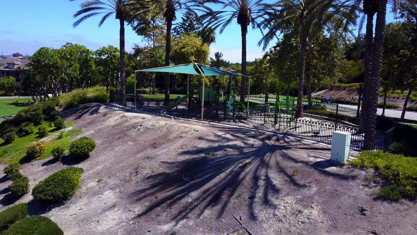 Aerial rotation from a park to a shopping mall with mountains in the background