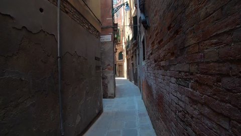 4K. Walking through of a narrow street in Venice, Italy. Subjective shot of a person who is walking on an old way.