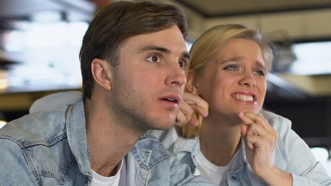 Caucasian couple watching match in bar, upset about favorite team losing game