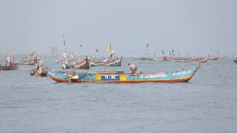 James Town, Ghana - 2018: Fishermen prepare wooden canoes at a small harbour.