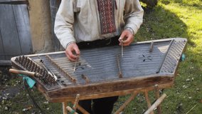Local man playing a gusli. a traditional. Slavic musical instrument. at a cultural village in Ukraine.