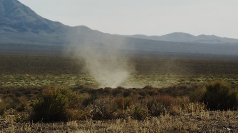 Dust devil, whirlwind, desert tornado churns through the dry Mojave desert scrub