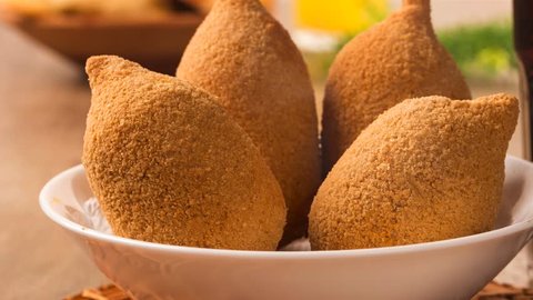 Slide shot Brazilian deep fried chicken snack with smoke, popular at local parties. Served with chili sauce. Coxinha de frango in Brazil.