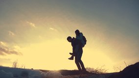 father and daughter teamwork happy family tourists silhouette concept rides on his back funny video . team dad and daughter on sunset play dabble livestyle the top of the mountain with backpacks
