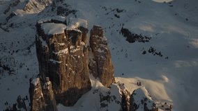 Spectacular drone aerial video in winter, at sunset time in Dolomites, to the Cinque Torri rocks.