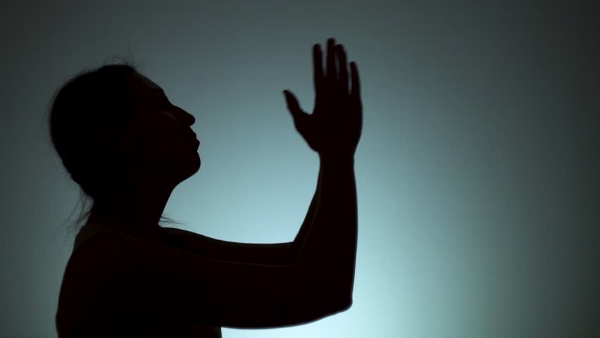 Silhouette of a woman. The shadow of a woman on a light background. A woman prays to God, folding his arms and stretching them up. Emotions, prayer, religion, faith. Slow motion. | Shutterstock HD Video #1026466040