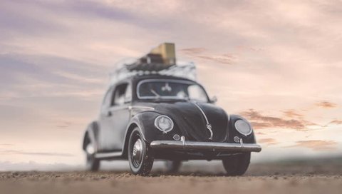 NITRA, SLOVAKIA - JUNE 28 2018: Volkswagen Beetle with suitcases on the roof by sunset. Sunset over Volkswagen Beetle. Classic car VW Beetle by summer sunset.