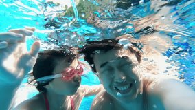 cute daughter and father paly and selfie happily in the swimming pool