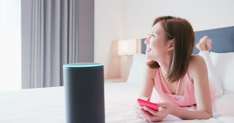 IOT smart home concept - woman talk voice assistant to turn on the lights and the curtain of house