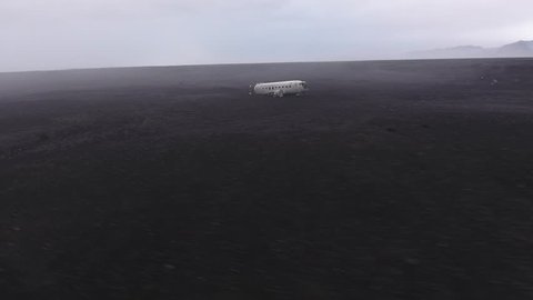 Large aerial view by drone of the Wrecked DC3 Plane with the mountains and the sea near by on the Solheimasandur beach in Iceland