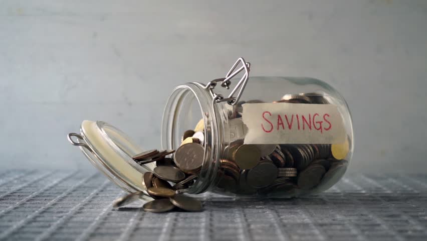 Slow motion coins money dropped out from glass jar with savings label, financial concept. | Shutterstock HD Video #1026483959