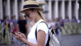 Happy woman taking pictures while chatting with friend on web page via cellular phone connected to roaming internet, cheerful female tourist in sunglasses photographing architecture during sightseeing